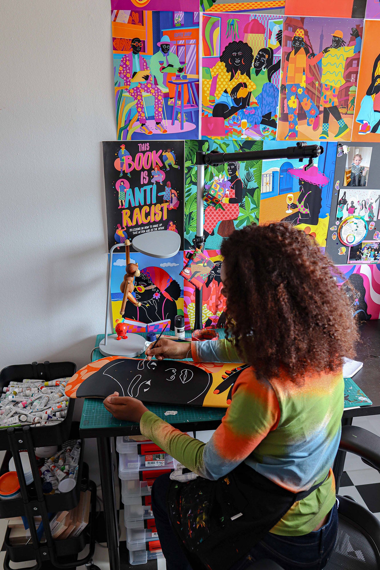 Aurélia Durand painting on a skateboard with colorful art in her atelier